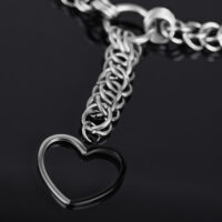 Silberne Herz Choker Kette aus Chirurgenstahl Silberne Choker Kette mit großem Herzanhänger auf schwarzem Hintergrund
