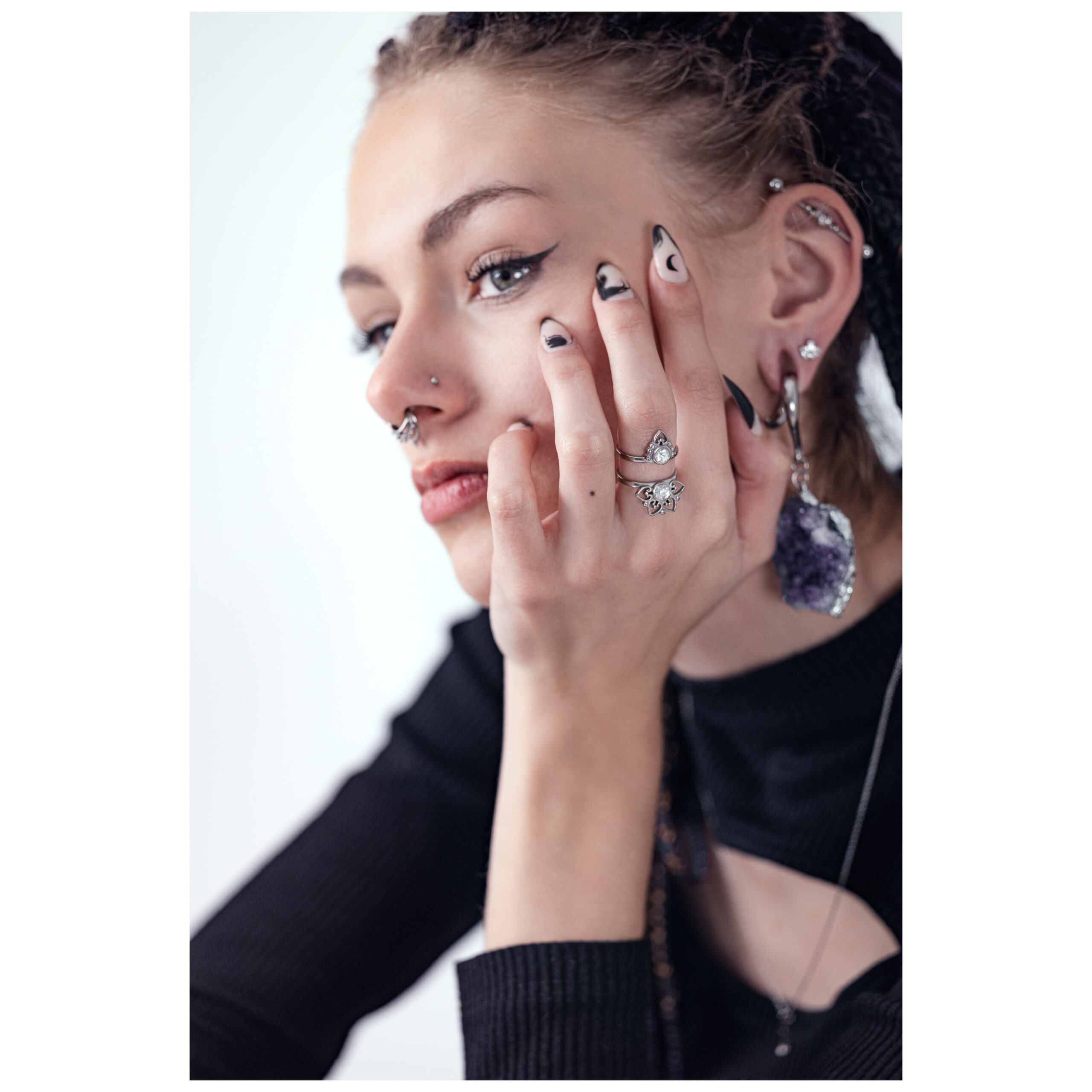 Silberner Ring Silver Sun Tides von Wildcat Frau mit Silberring Silver Sun Tides, Hand am Gesicht, schwarzes Oberteil