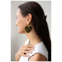 Goldene Soulmate Hoops Ohrringe am Ohr Frau mit langen Haaren trägt goldene Soulmate Hoops Ohrringe, weißes Oberteil, nahaufnahme