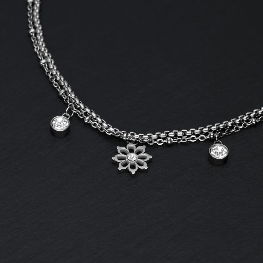 Silbernes Armband auf schwarzem Hintergrund mit floralen Anhängern und Kristallen