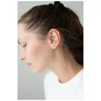 Auffälliger Ohrstecker Double Beam Crystal Silberne Ohrstecker mit Kristallen am Ohr einer Frau auf neutralem Hintergrund