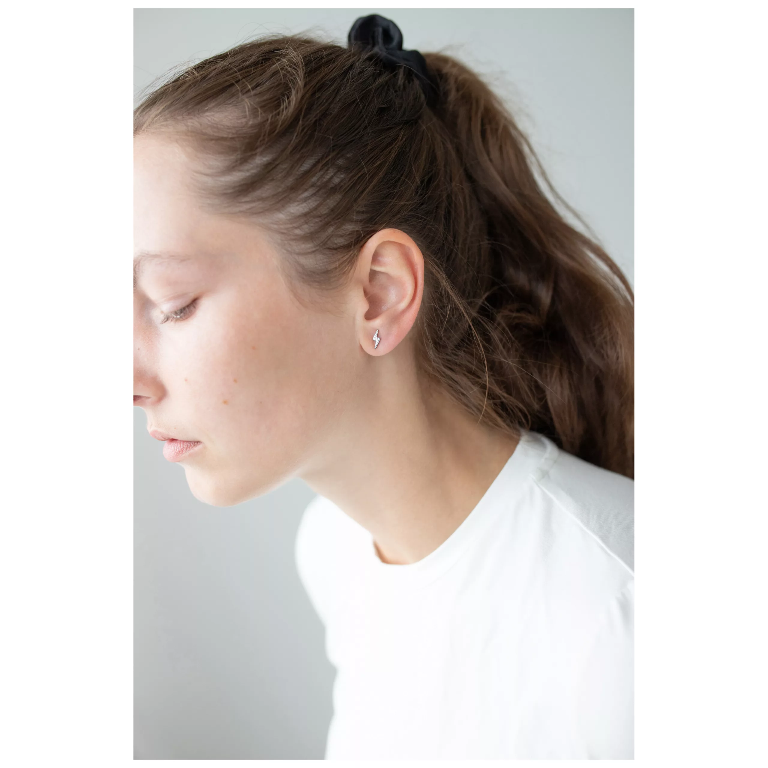 Elegante Kristall-Ohrstecker in Silber Frau mit langen Haaren trägt silberne Kristall-Ohrstecker