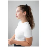 Elegante kurze Spike-Creolen in Schwarz Frau mit langen Haaren trägt schwarze Spike-Creolen vor grauem Hintergrund