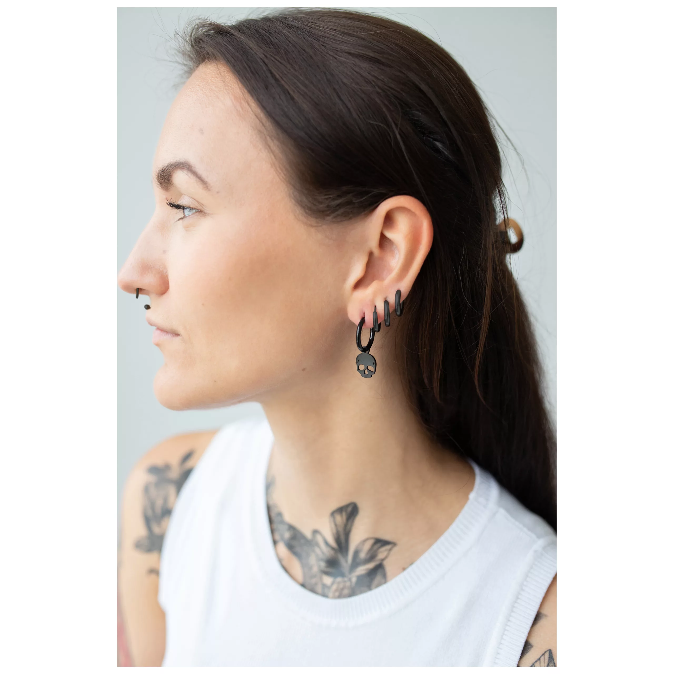 Frau mit schwarzen Little Skull Hoops Ohrringen aus Chirurgenstahl