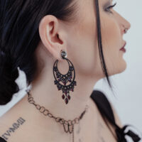 Barocke Chandelier Hoops in Schwarz Schwarze barocke Ohrringe aus Chirurgenstahl am Ohr einer Frau, seitliches Profil