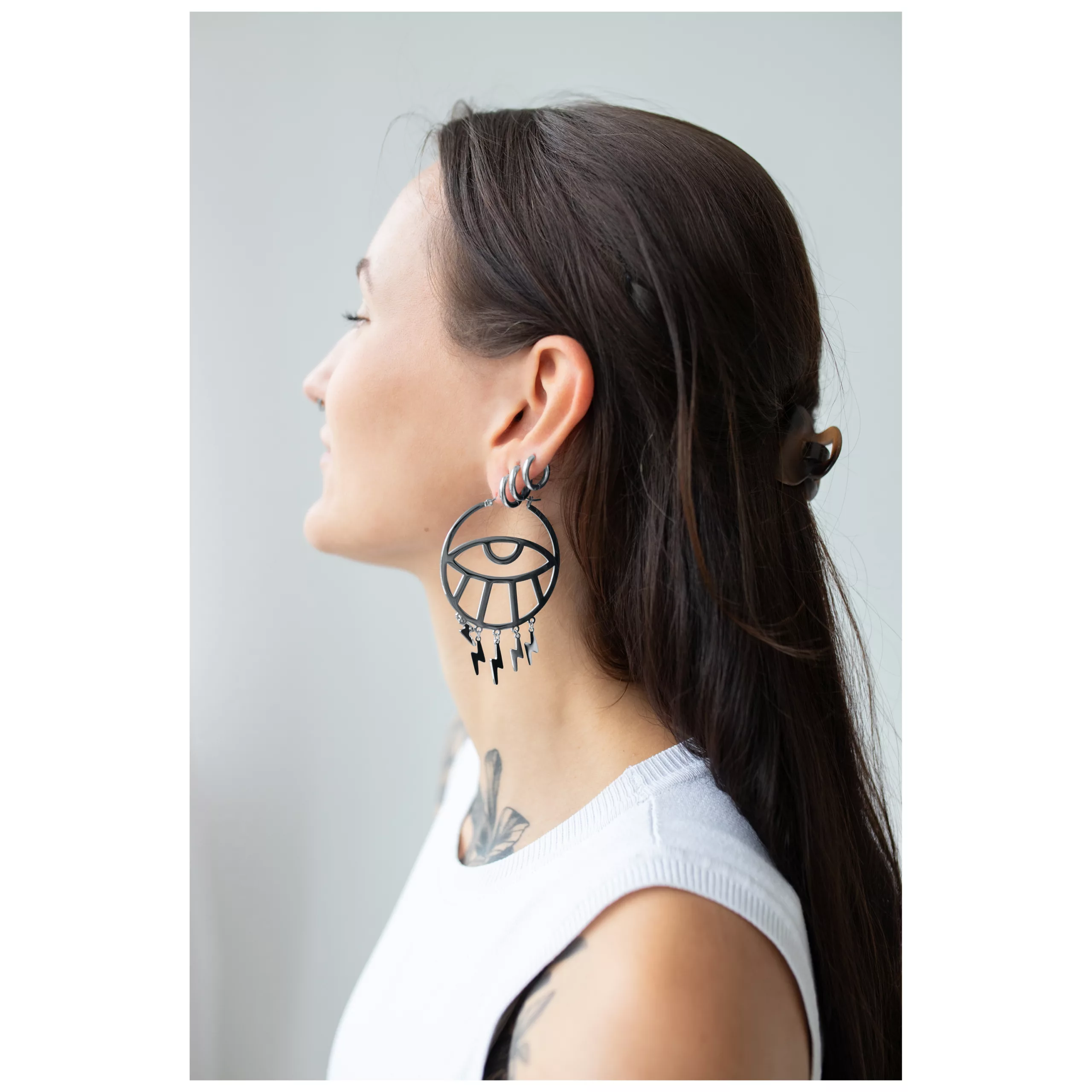 Frau mit langen Haaren trägt große schwarze Thunderflash Eye Hoops Ohrringe seitlich