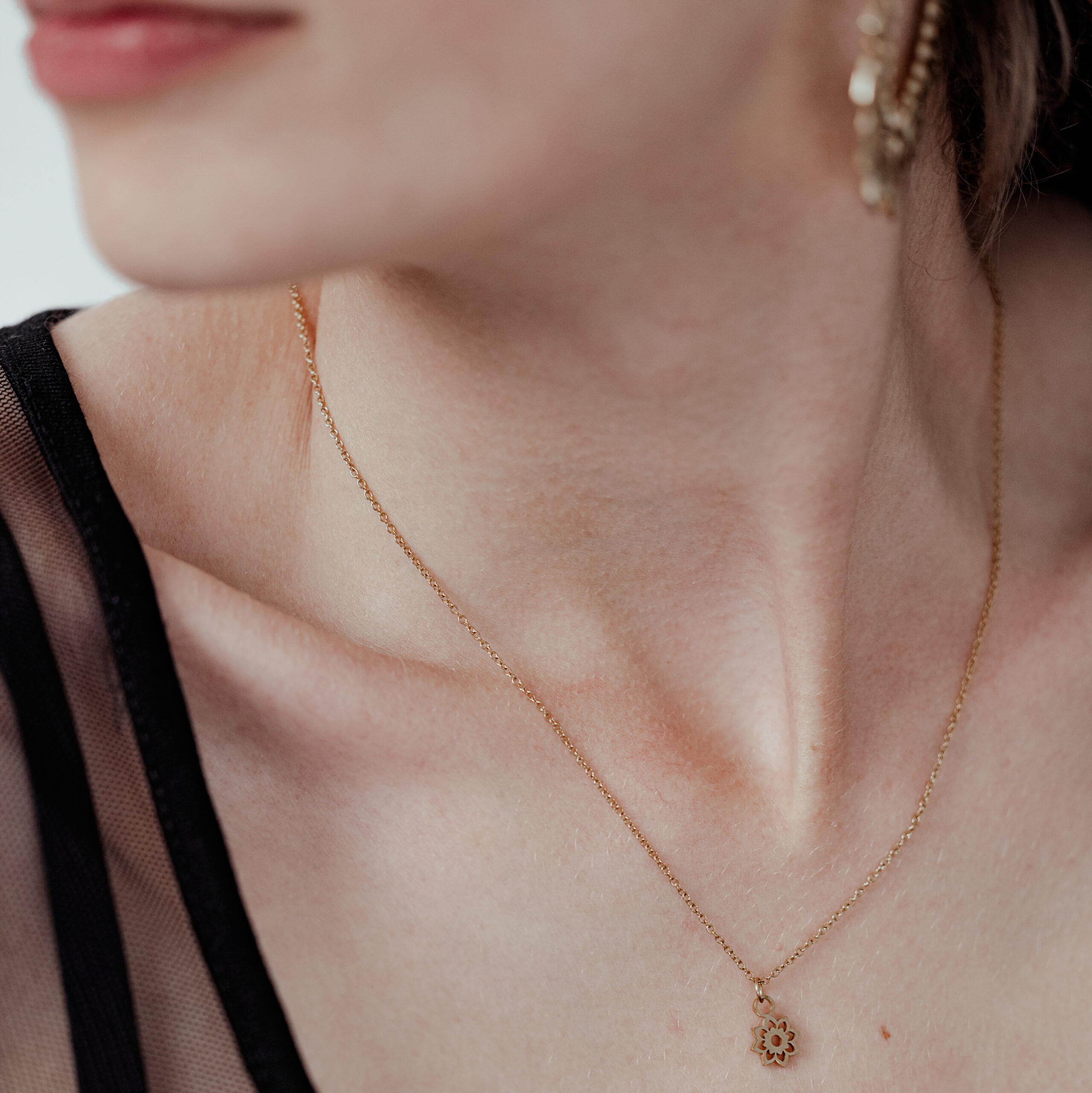 Goldene Little Sunflower Kette für Damen Dame mit goldener Little Sunflower Kette, filigran und elegant, auf hellem Hintergrund