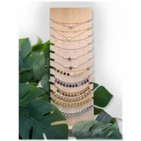 Schwarzes Display für Armbänder und Halsketten Holzdisplay mit schwarzen Kunstlederakzenten, umgeben von Pflanzen