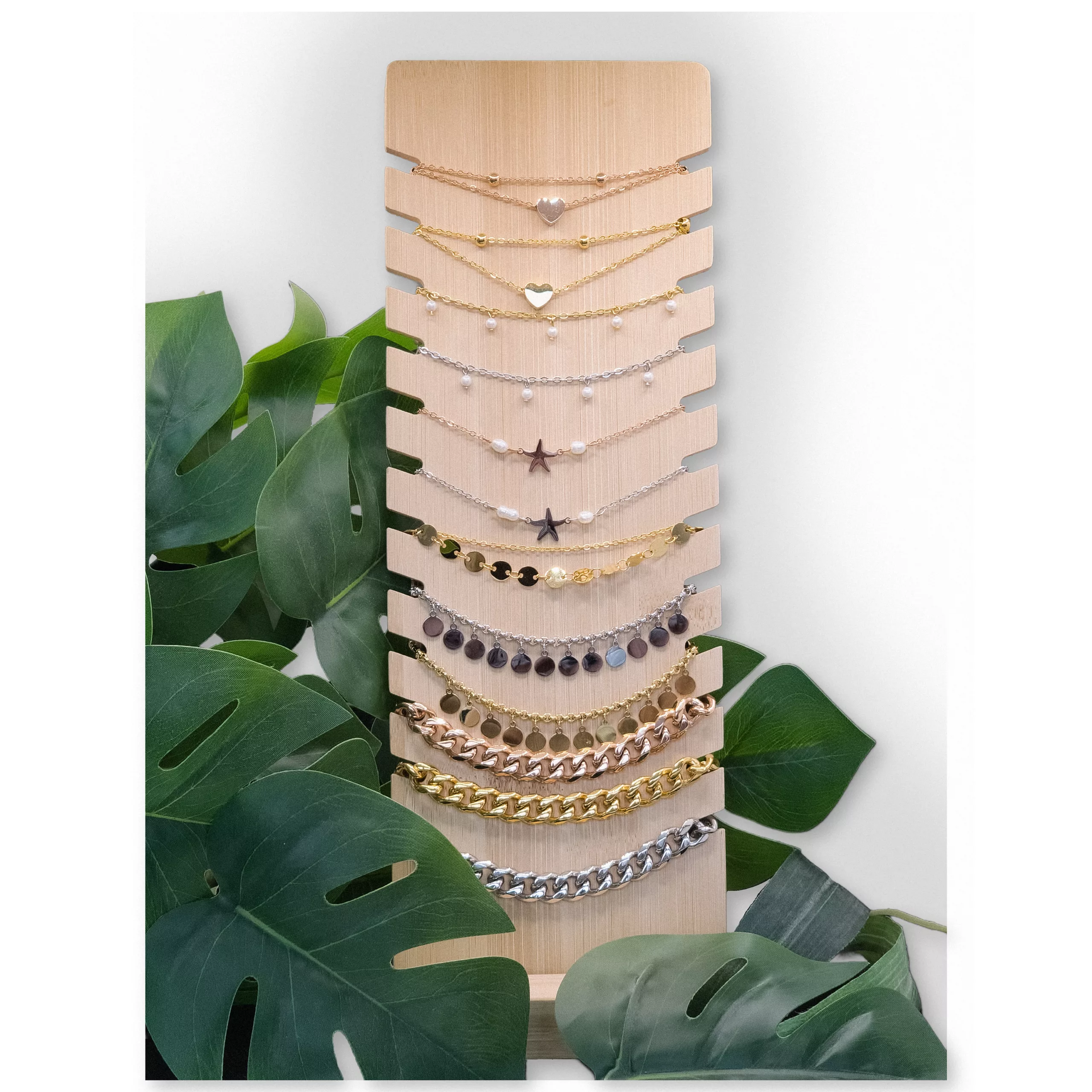 Schwarzes Display für Armbänder und Halsketten Holzdisplay mit schwarzen Kunstlederakzenten, umgeben von Pflanzen