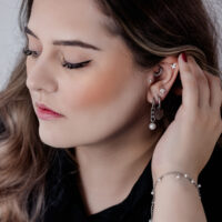 Frau mit eleganten schwarzen und silbernen Chunky Pearl Hoops und anderen Ohrpiercings