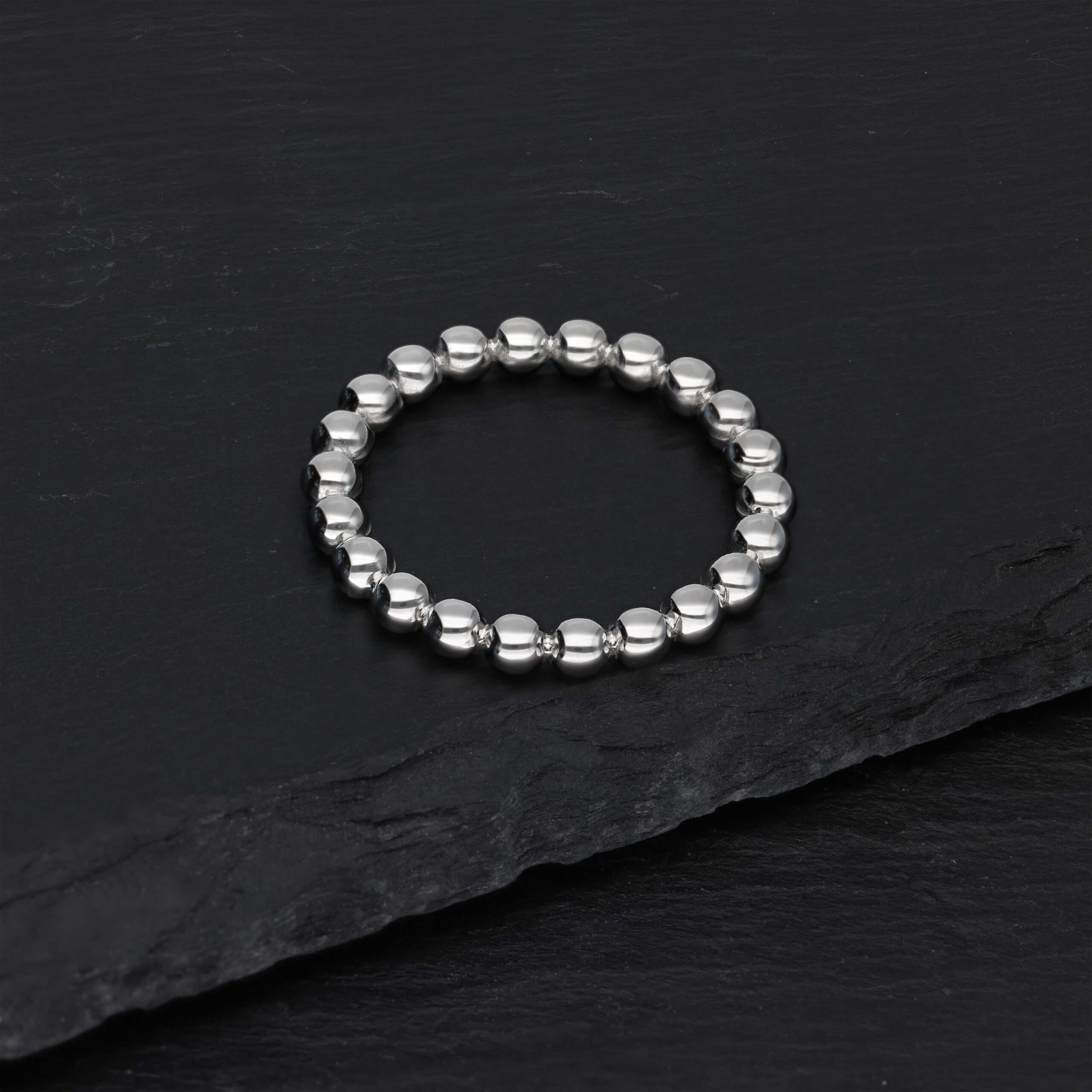 Silberner Bubble Ring aus Chirurgenstahl Silberner Bubble Ring auf schwarzem Hintergrund liegend