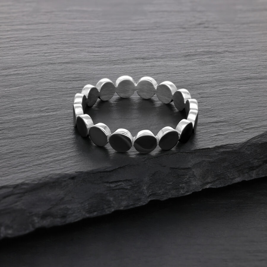Silberner Ring aus Chirurgenstahl auf dunkler Steinoberfläche