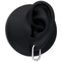 Silberne Oval Bubble Hoops am schwarzen Ohr auf neutralem Hintergrund
