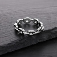 Silberner Link Chain Ring aus Chirurgenstahl Silberner Link Chain Ring aus Chirurgenstahl auf dunklem Stein