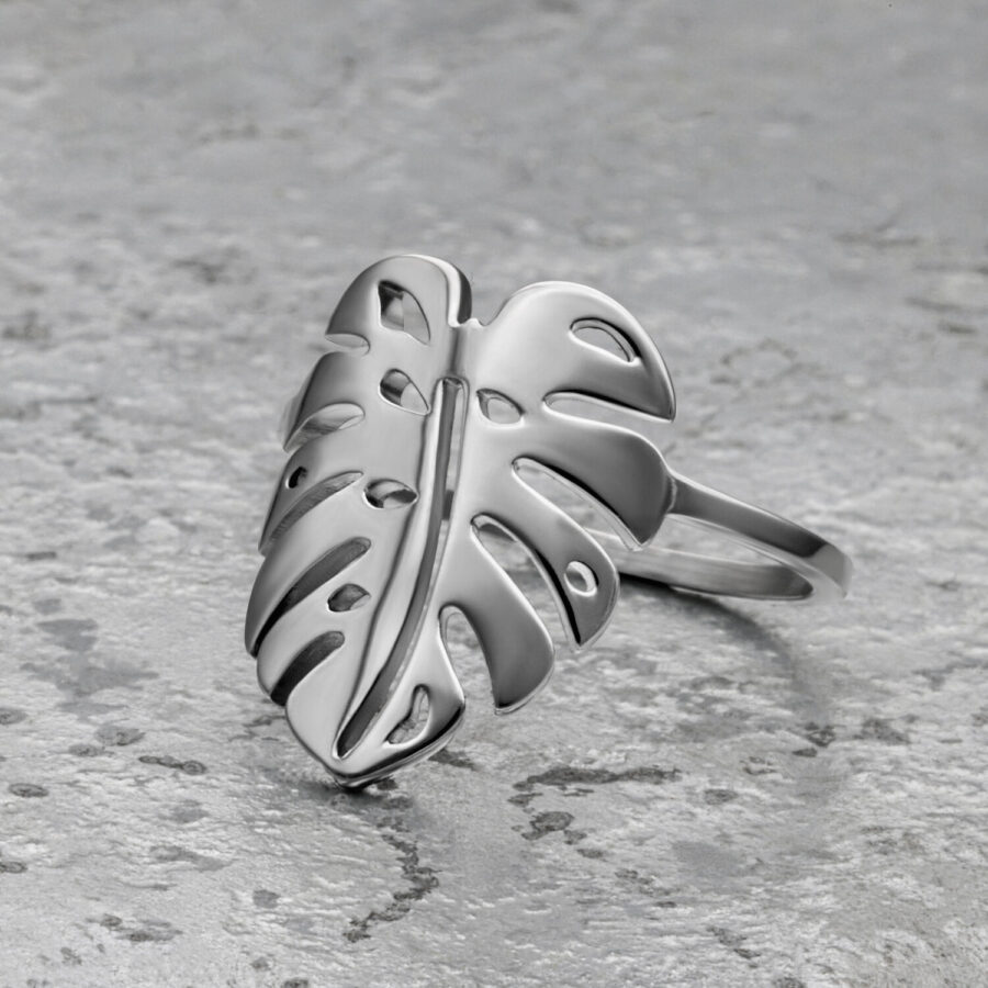 Silberner Monstera Blatt Ring aus Chirurgenstahl auf grauem Hintergrund