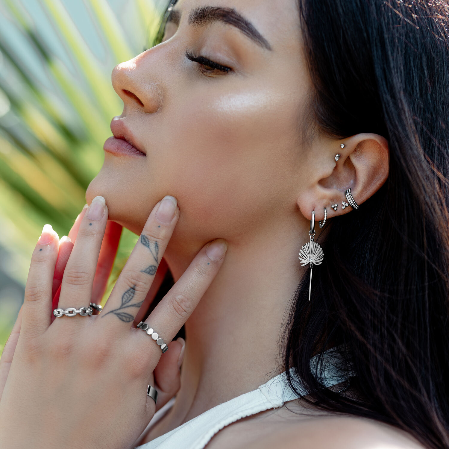 Elegante Little Petticoat Hoops im Ohr getragen Frau mit mehreren Ohrringen, darunter Little Petticoat Hoops, im Ohr, im Freien