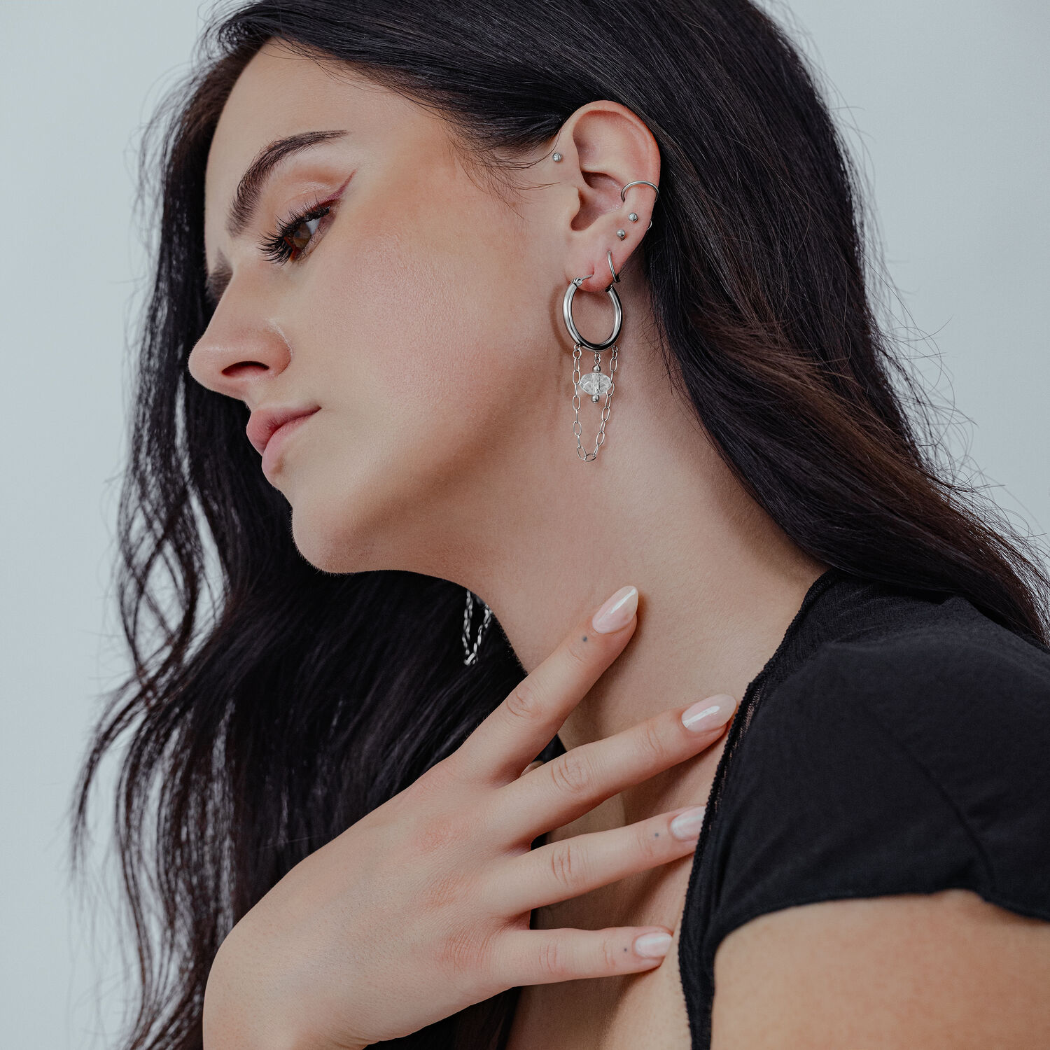 Edgy weiße Stone Hoops an Ohr Frau mit langen dunklen Haaren trägt weiße Stone Hoops aus Chirurgenstahl am Ohr