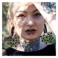 Schwarze Floral Hoops aus Chirurgenstahl Frau mit großen schwarzen floralen Ohrringen aus Chirurgenstahl