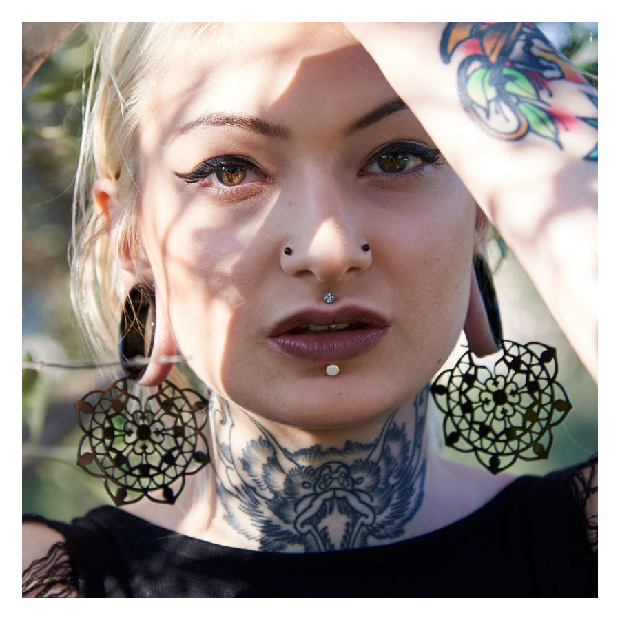 Schwarze Floral Hoops aus Chirurgenstahl Frau mit großen schwarzen floralen Ohrringen aus Chirurgenstahl