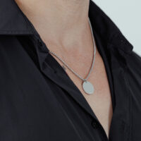 Gravierbare Basic Kette aus Chirurgenstahl Silberne Kette mit rundem Anhänger an einem schwarzen Hemd
