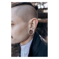 Stylische Ear Saddles aus Chirurgenstahl Mann mit silbernen Ear Saddles im Ohr vor unscharfem Hintergrund