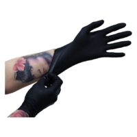 Schwarze Nitrilhandschuhe von Wildcat Schwarze Nitrilhandschuhe, getragen von tätowierter Hand, auf weißem Hintergrund