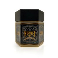 Schwarzes und goldenes Hornet Honey Butter Glas auf weißem Hintergrund