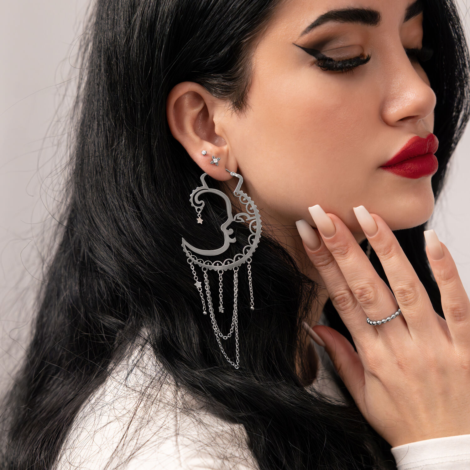 Frau mit silbernen Sun Moon Hoops, seitliches Profil, glatter Hintergrund